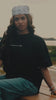 Person wearing a black exactitudeworld t-shirt brand with 'EXACTITUDE' printed on the front